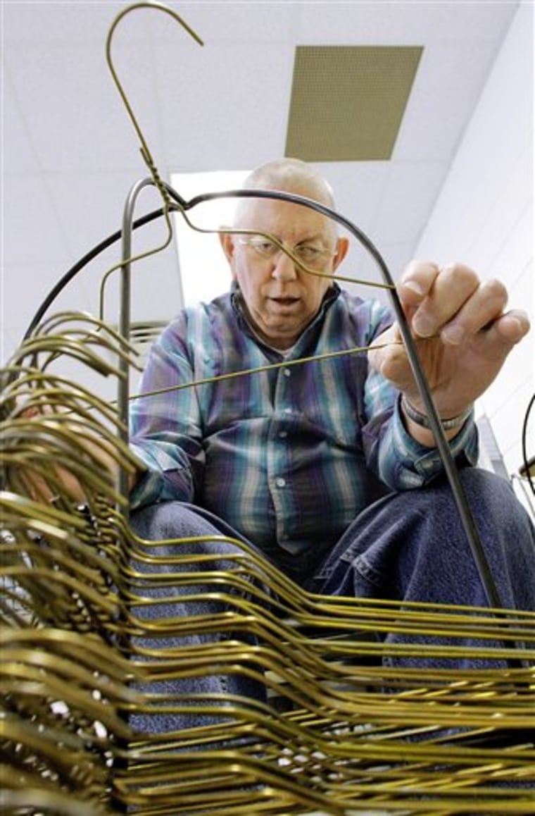 Ed Harp straightens hangers at SPARC, an agency that helps people with developmental disabilities, in Springfield, Ill. The state owes SPARC about $2.5 million.